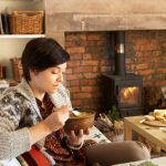 Young woman eating by fire